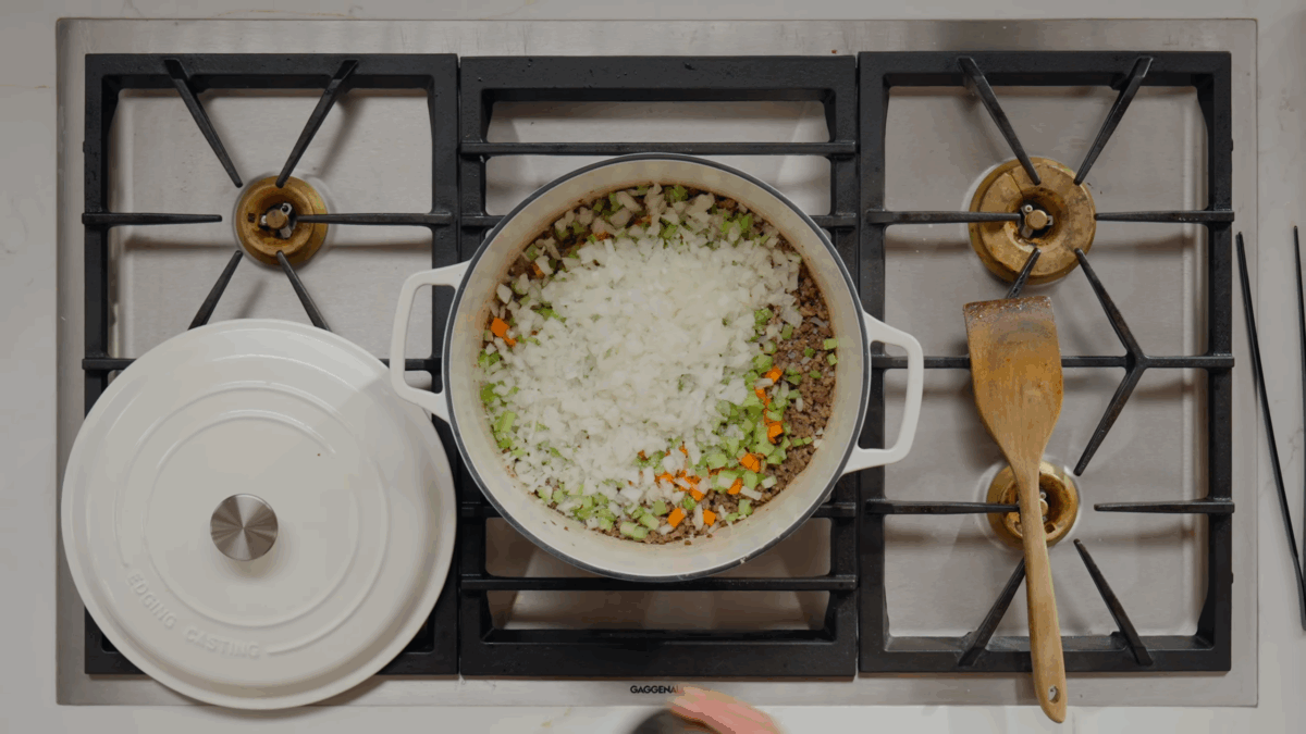 Ground pork, ground beef, celery, onions, carrots, salt, and pepper in a Dutch oven.