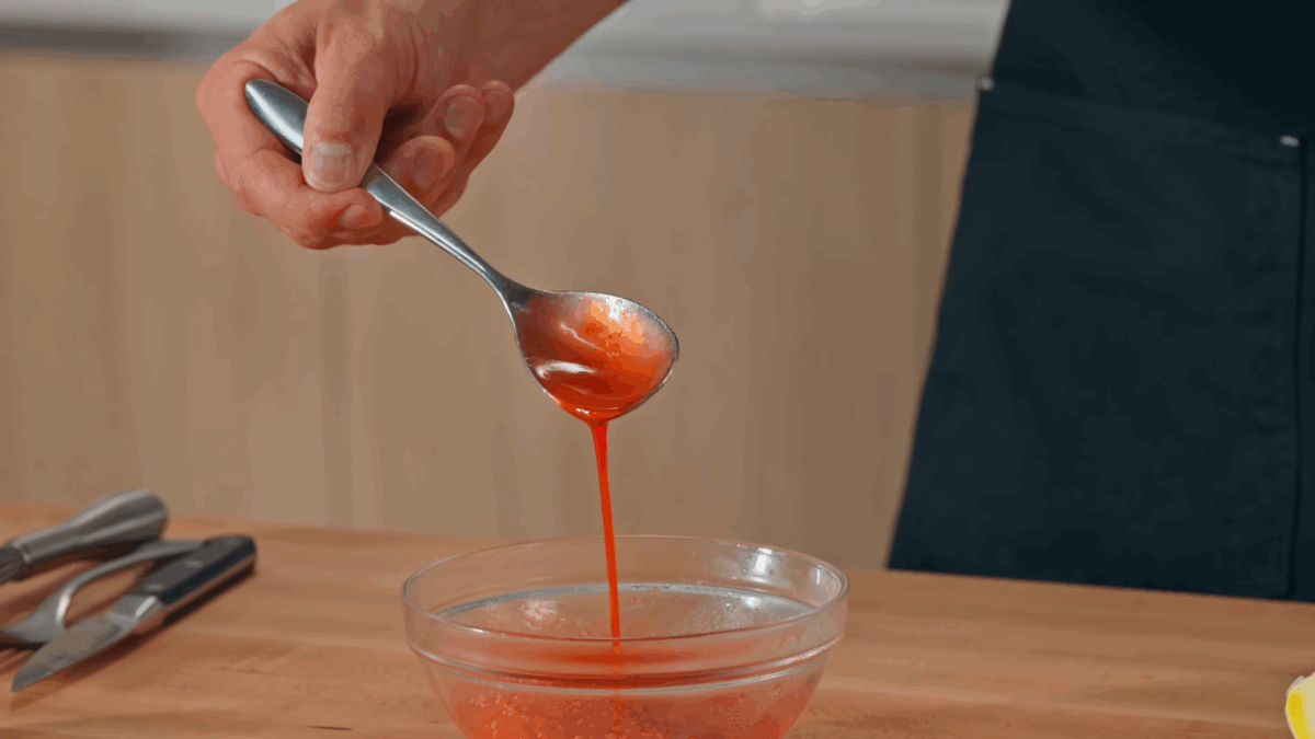 Nick DiGiovanni lifting a scoop of raspberry coulis from a bowl.