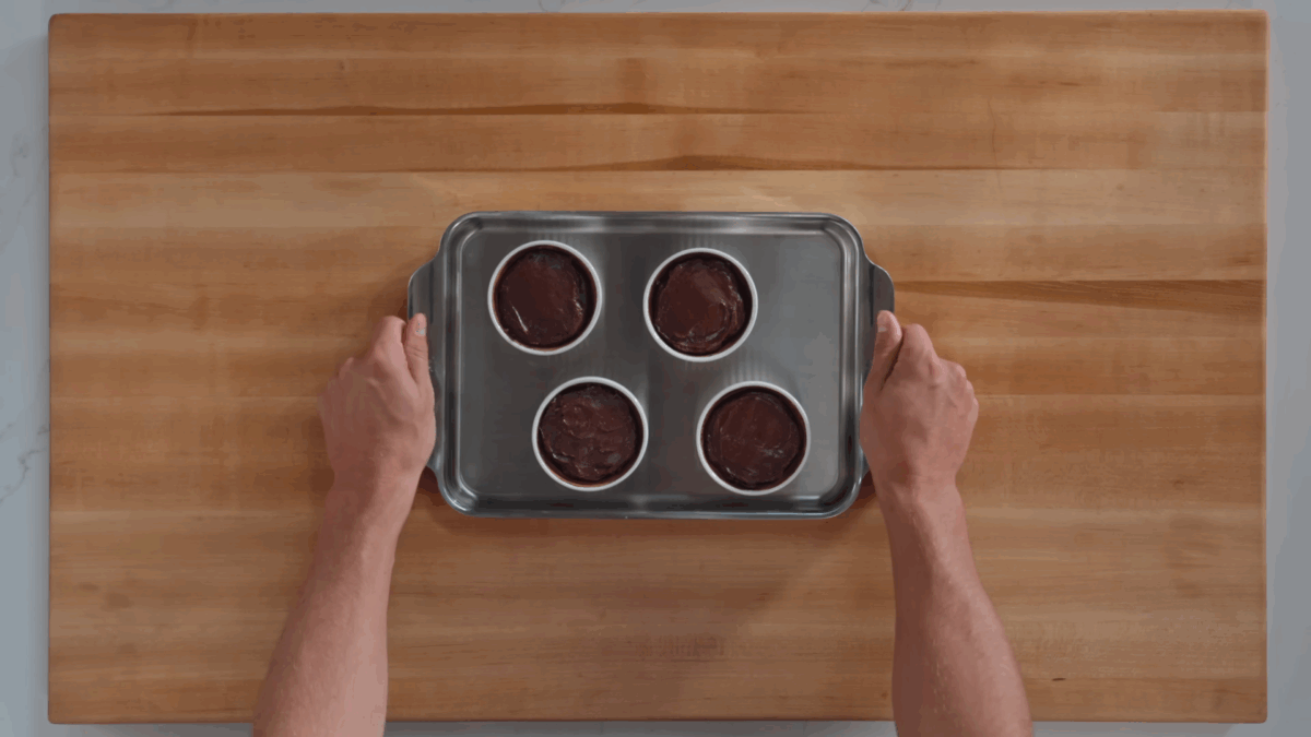 Four ramekins of unbaked chocolate lava cake.