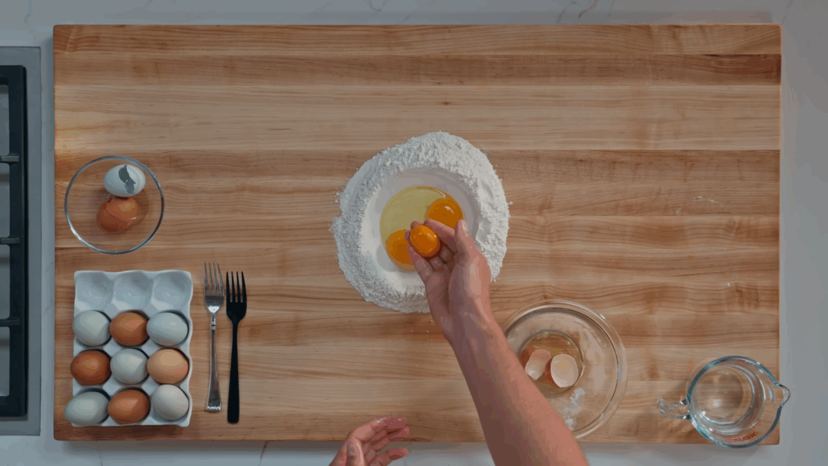 Nick DiGiovanni making a well of flour with eggs, egg yolks, and salt.