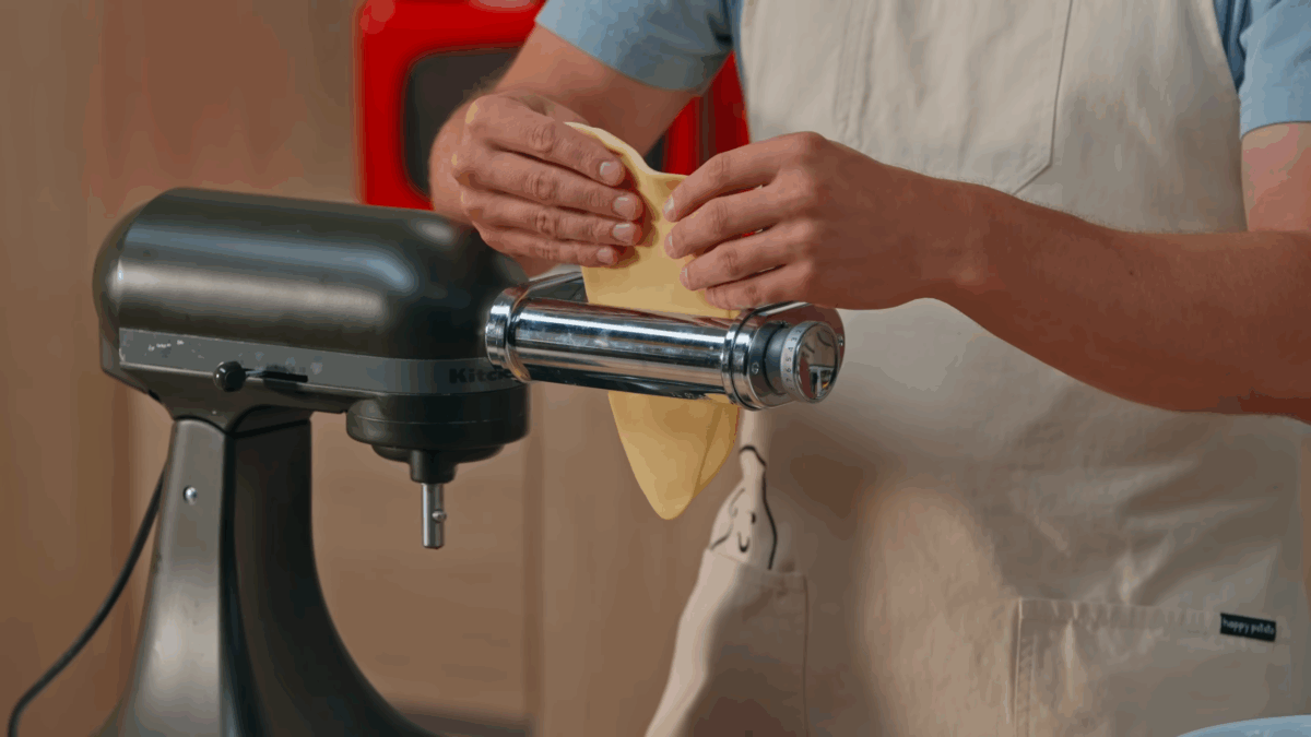 Nick DiGiovanni rolling pasta dough through a stand mixer.