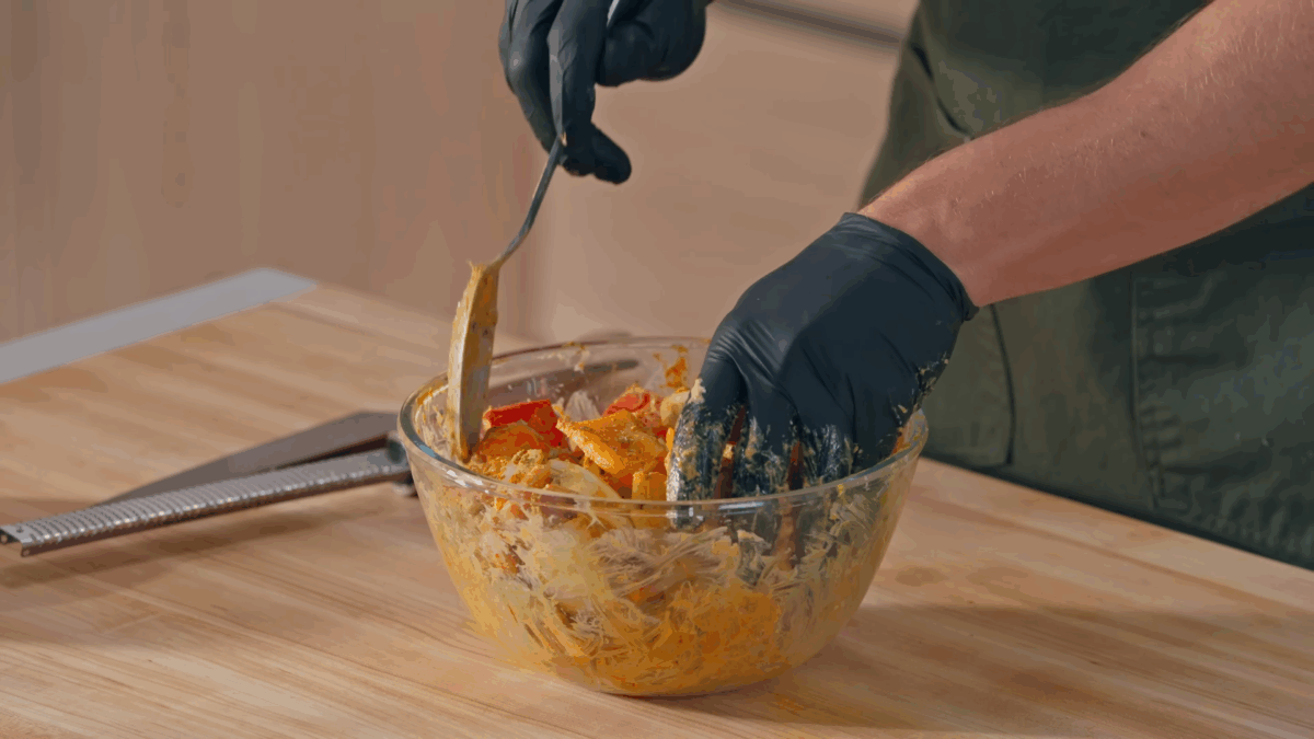 Nick DiGiovanni coating chicken thigh pieces in chicken tikka masala sauce.