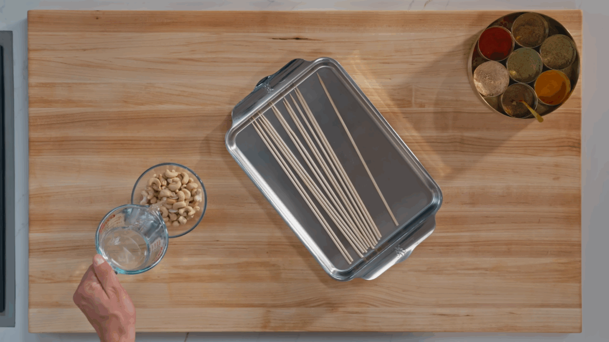 Nick DiGiovanni pouring water over a bowl of cashews.