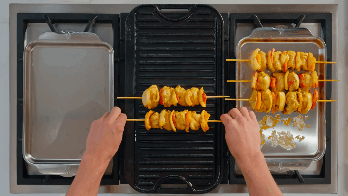 Nick DiGiovanni placing chicken tikka masala on a grill pan.