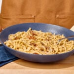 A bowl of pasta carbonara, a fork sticking out.