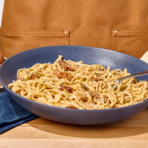 A bowl of pasta carbonara, a fork sticking out.