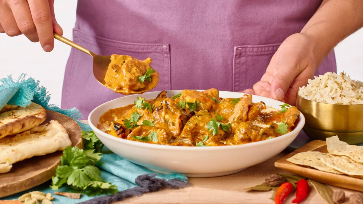Nick DiGiovanni lifting a scoop of chicken tikka masala from a bowl.