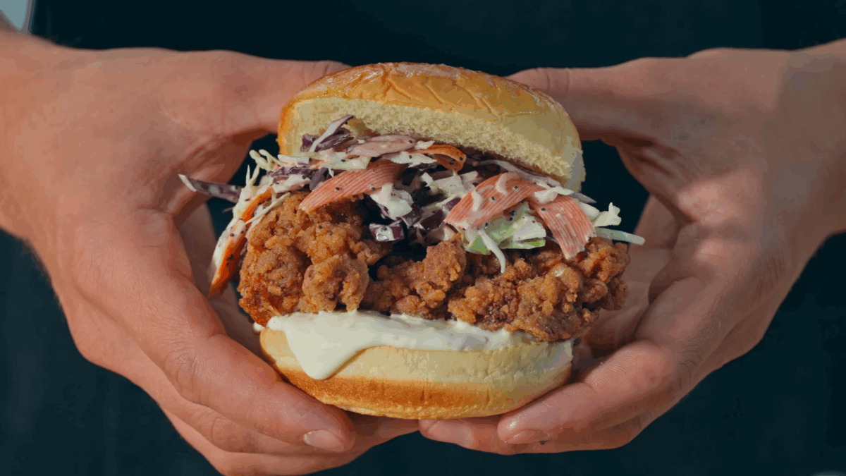 Nick DiGiovanni holding a fried chicken sandwich with two hands. 