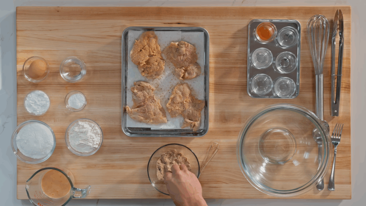 Nick DiGiovanni seasoning raw marinated chicken thighs. 