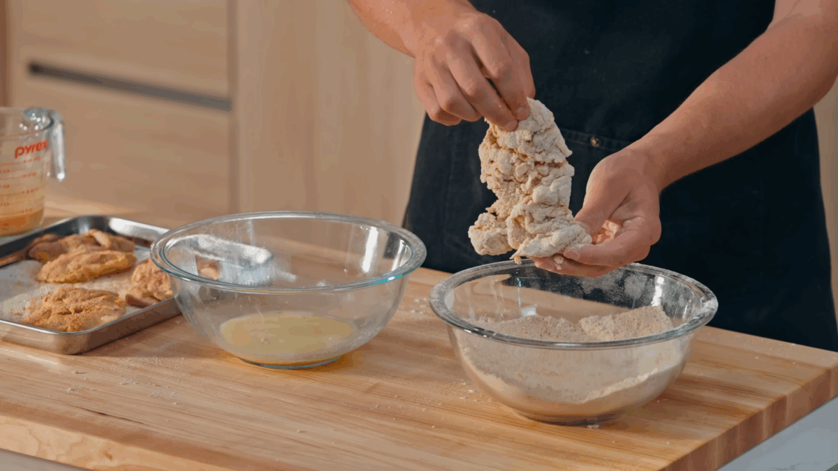 Nick DiGiovanni breading raw marinated chicken thighs. 
