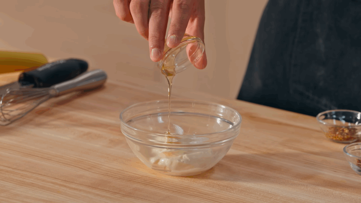 Nick DiGiovanni combining sauce ingredients for a fried chicken sandwich in a bowl. 