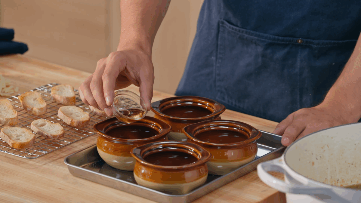 Nick DiGiovanni pouring sherry into bowls for French onion soup. 