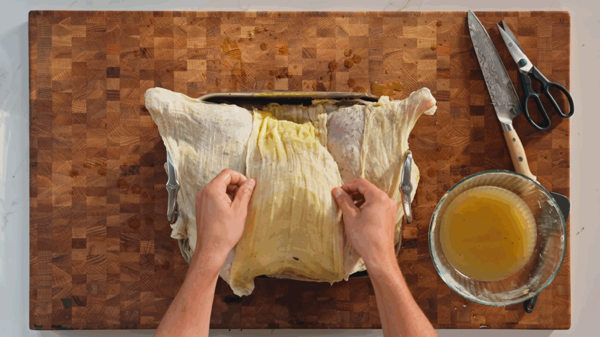 Nick DiGiovanni covering a spatchcocked turkey with a butter soaked cheesecloth. 