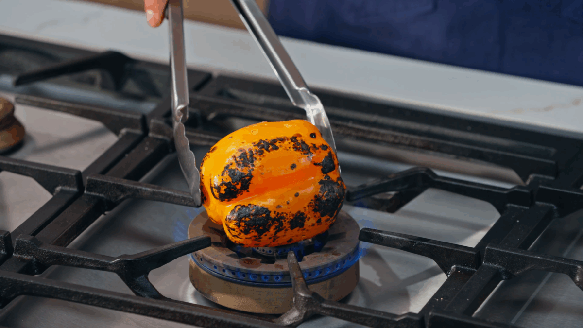 Nick DiGiovanni charring a pepper on a stovetop.