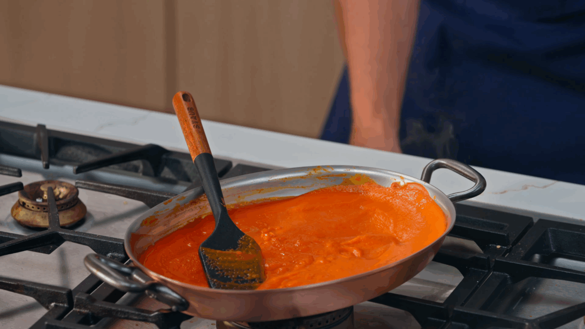 Piperade sauce reducing in a skillet.