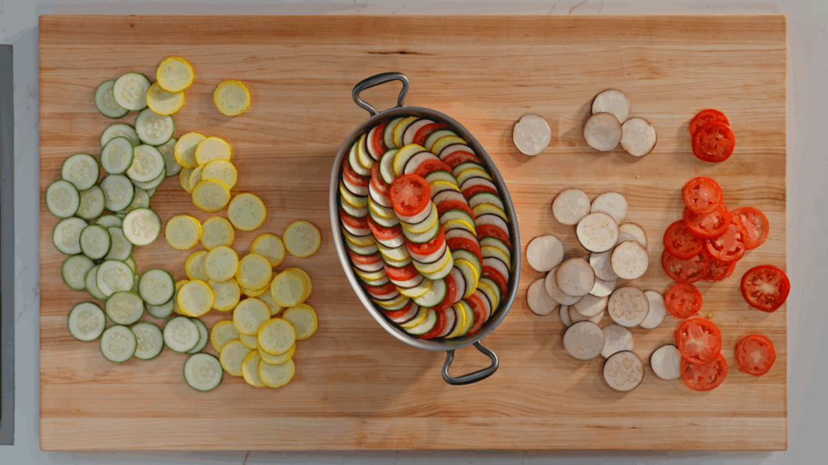 Uncooked ratatouille layered in a casserole dish.