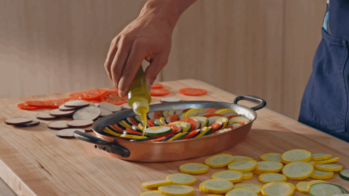 Nick DiGiovanni drizzling infused olive oil over ratatouille.