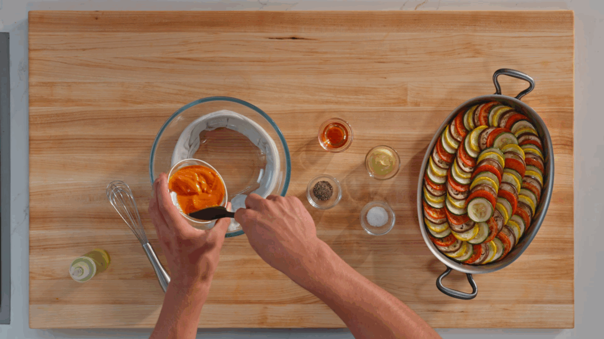 Nick DiGiovanni whisking piperade vinaigrette in a bowl.