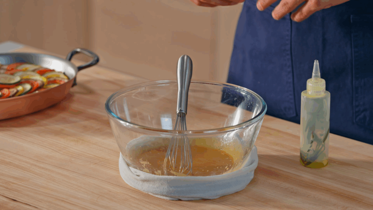 Piperade vinaigrette in a bowl with a whisk sticking out.