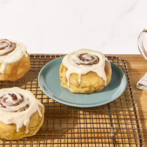 Cinnamon rolls on a wire rack.