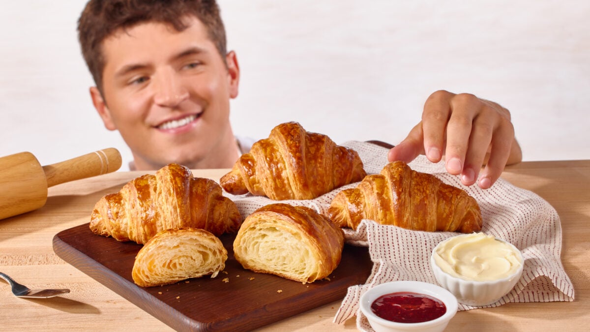 Nick DiGiovanni grabbing a homemade croissant from a platter. 