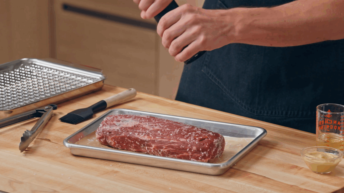 Nick DiGiovanni seasoning a raw beef tenderloin. 