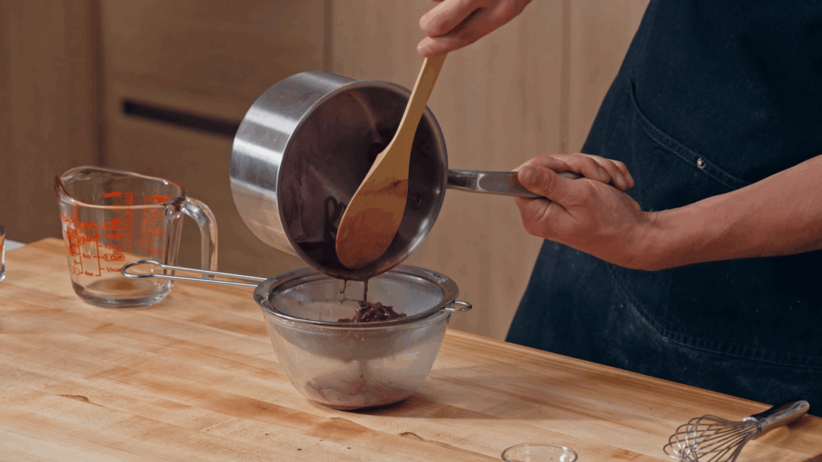 Nick DiGiovanni straining a wine reduction sauce. 