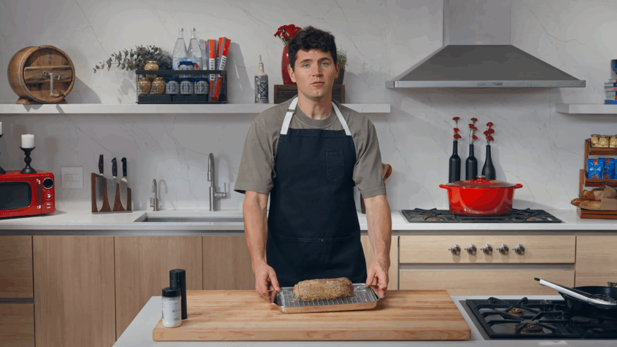 Nick DiGiovanni holding a beef tenderloin on a baking sheet. 