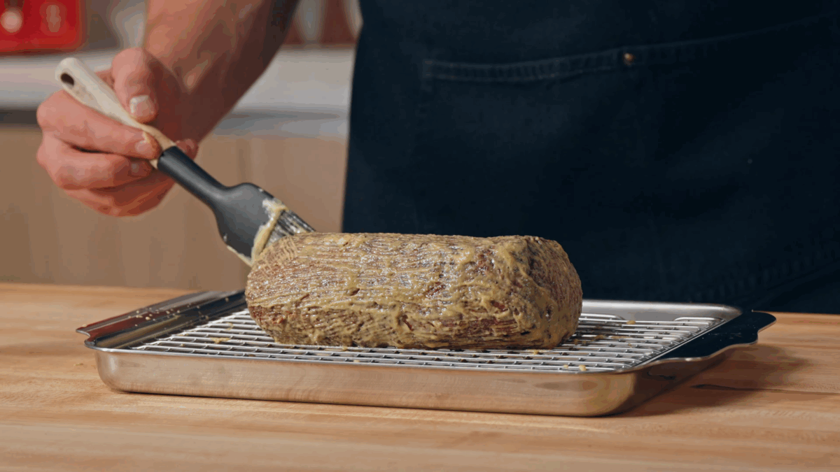 Nick DiGiovanni brushing a seared beef tenderloin with Dijon mustard. 