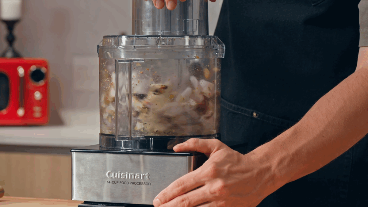 Nick DiGiovanni pulsing ingredients in a food processor. 