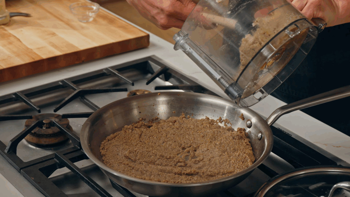 Nick DiGiovanni combining duxelles ingredients in a skillet on the stove. 