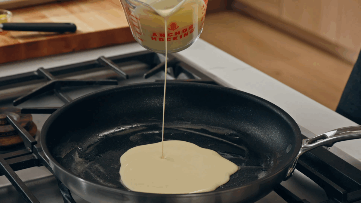 Nick DiGiovanni pouring cr&ecirc;pe batter into a pan. 