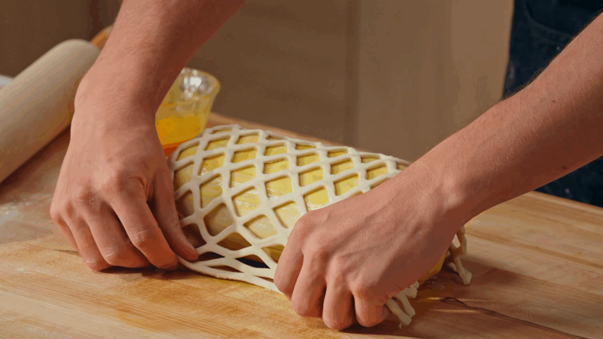 Nick DiGiovanni placing lattice dough on a Beef Wellington. 