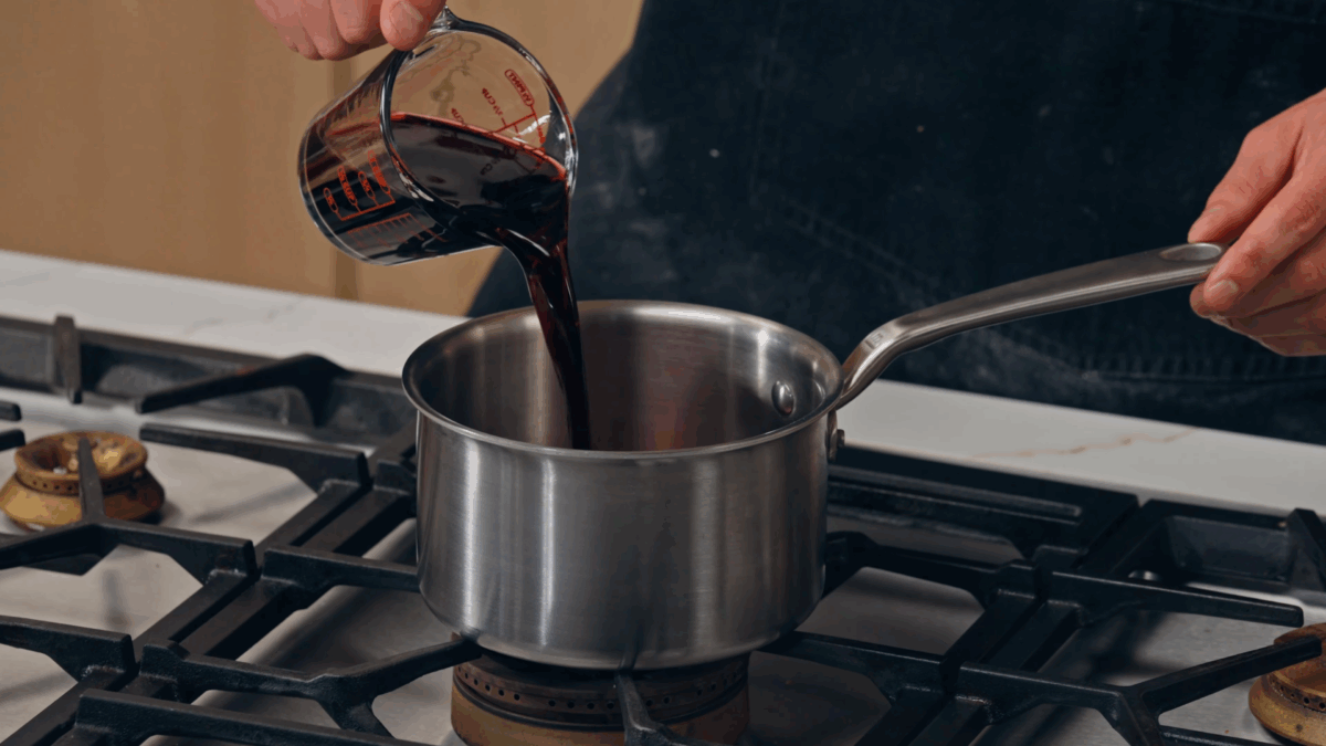 Nick DiGiovanni pouring wine into a saucepan. 