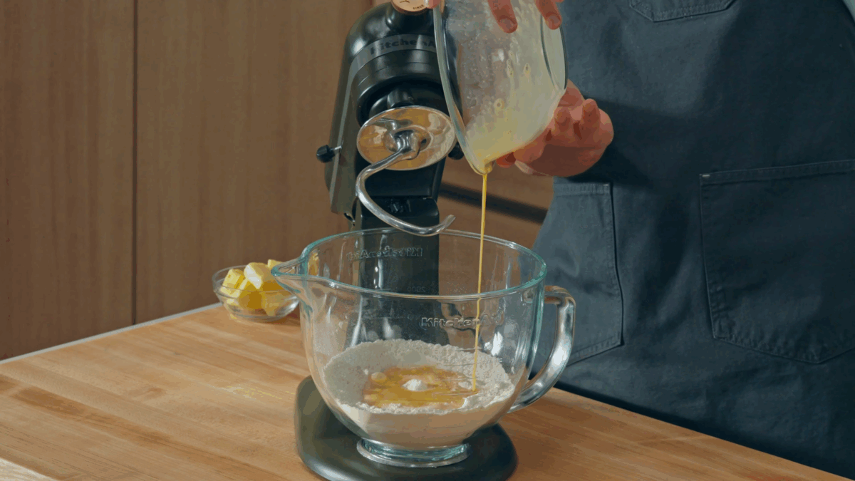 Nick DiGiovanni combining wet and dry ingredients for cinnamon rolls in a stand mixer. 