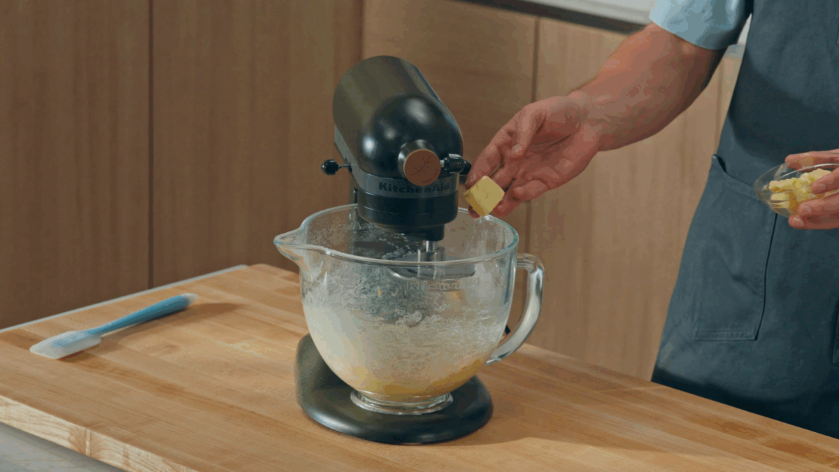 Nick DiGiovanni adding butter to the bowl of a stand mixer. 