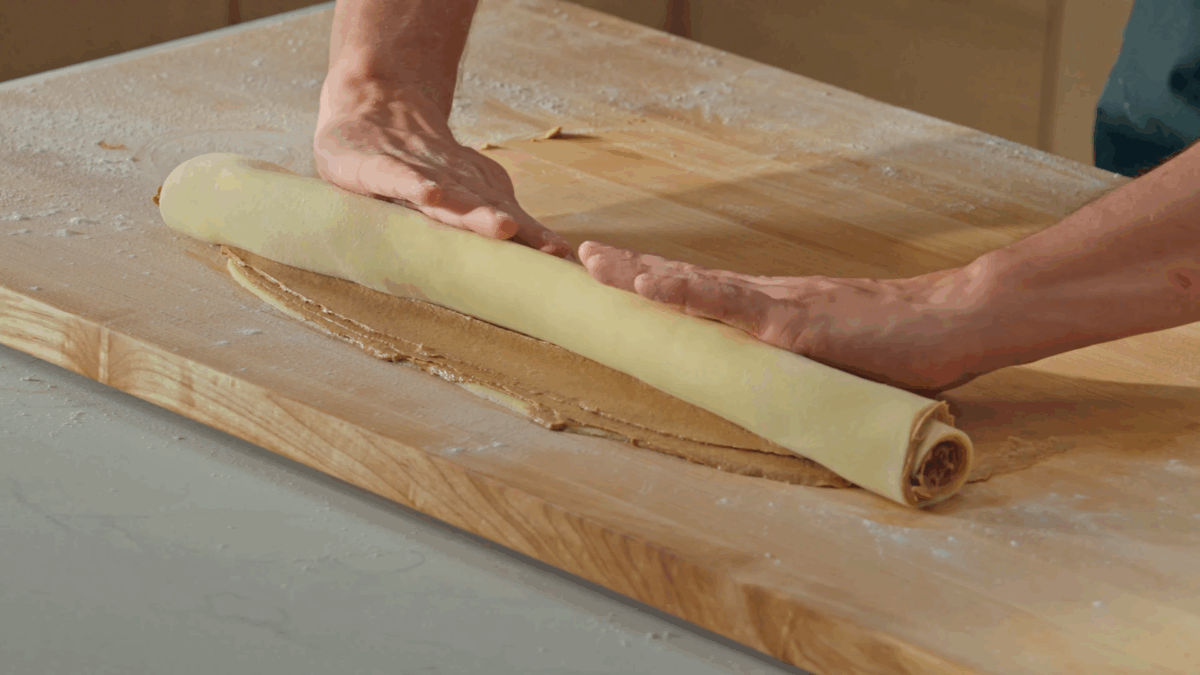 Nick DiGiovanni rolling raw cinnamon roll dough. 
