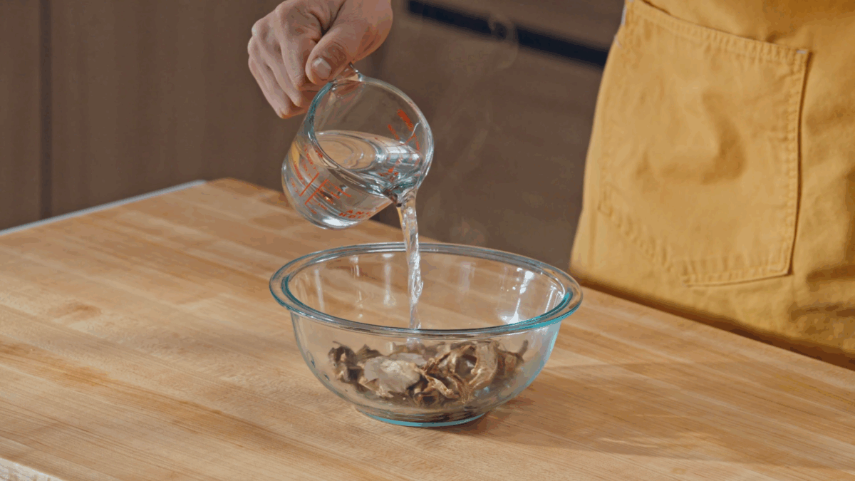 Nick DiGiovanni pouring hot water over dried mushrooms.