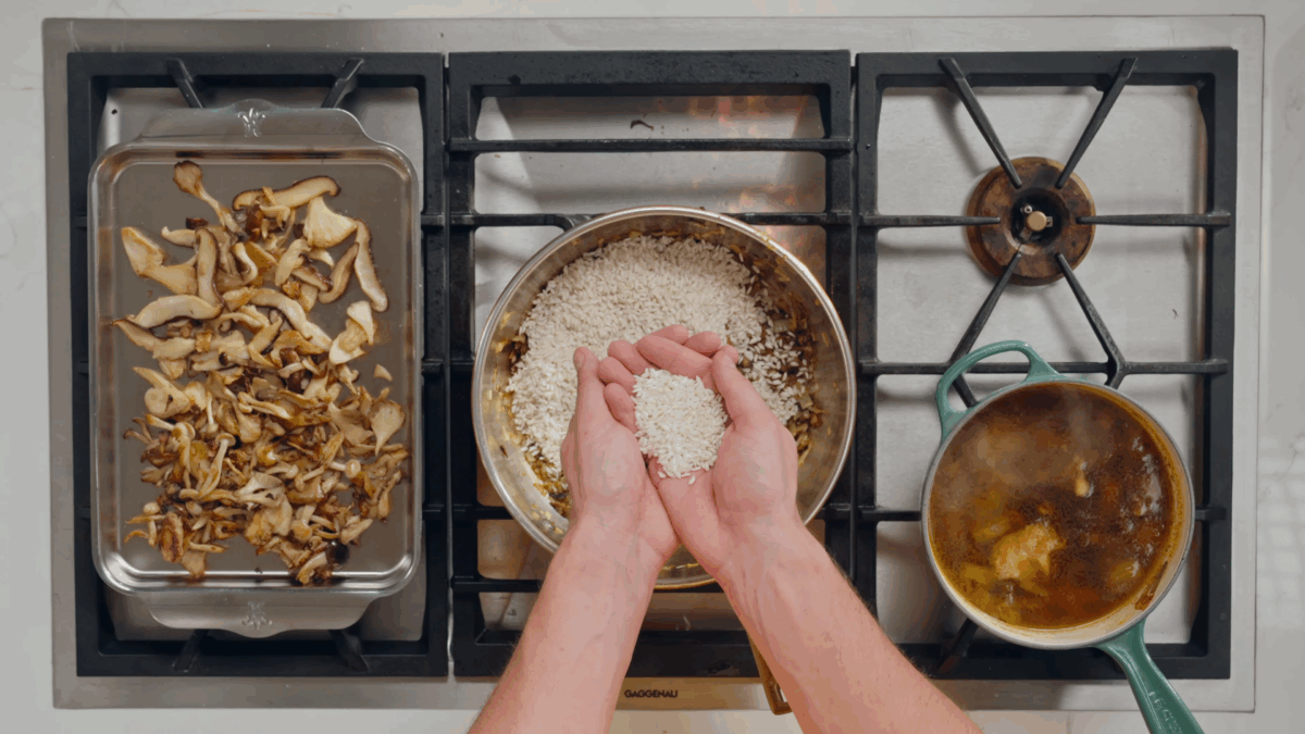 Nick DiGiovanni adding Arborio rice to a pot on the stovetop.