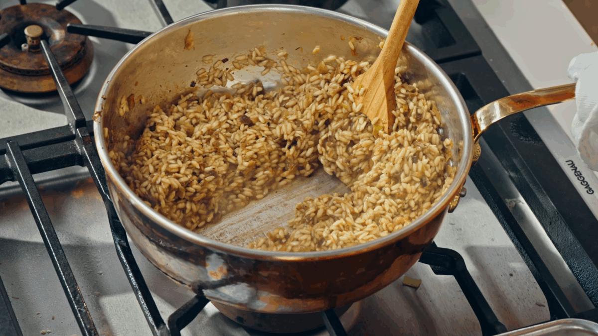 Nick DiGiovanni cooking mushroom risotto in a pot on the stovetop.