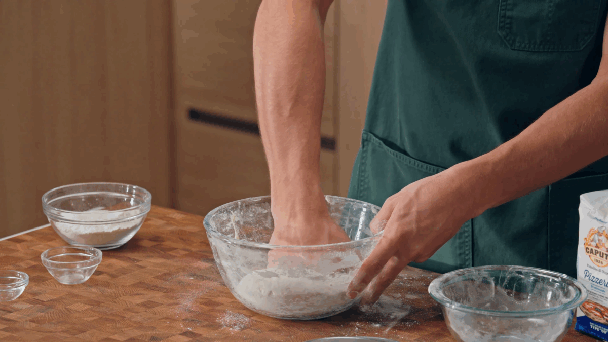 Nick DiGiovanni combining Neapolitan pizza dough ingredients in a bowl. 