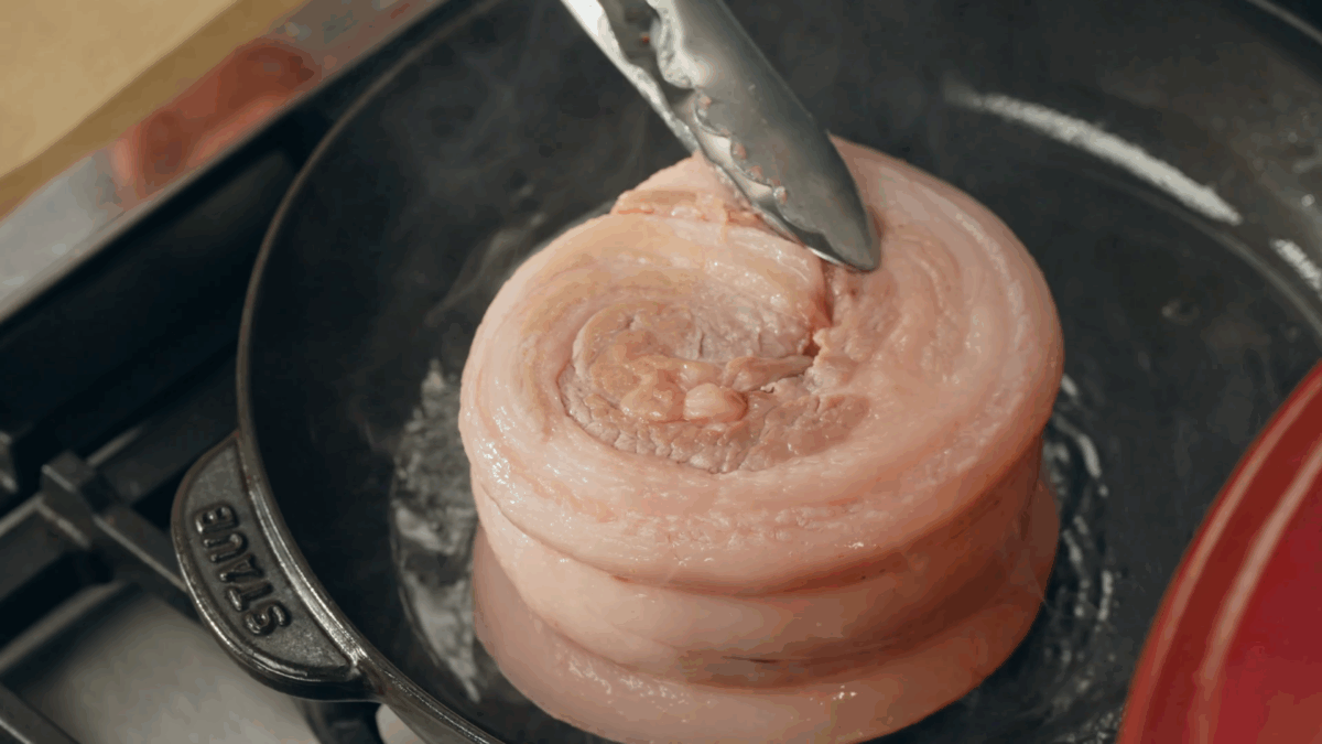 Nick DiGiovanni searing pork belly in a skillet. 