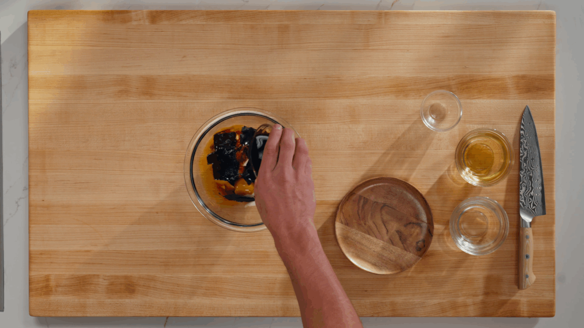 Nick DiGiovanni combining ramen egg ingredients in a bowl.
