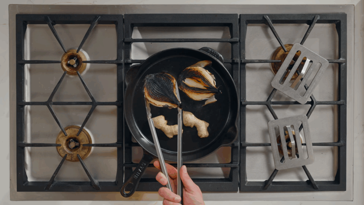 Nick DiGiovanni charring onions and ginger in a cast-iron skillet.