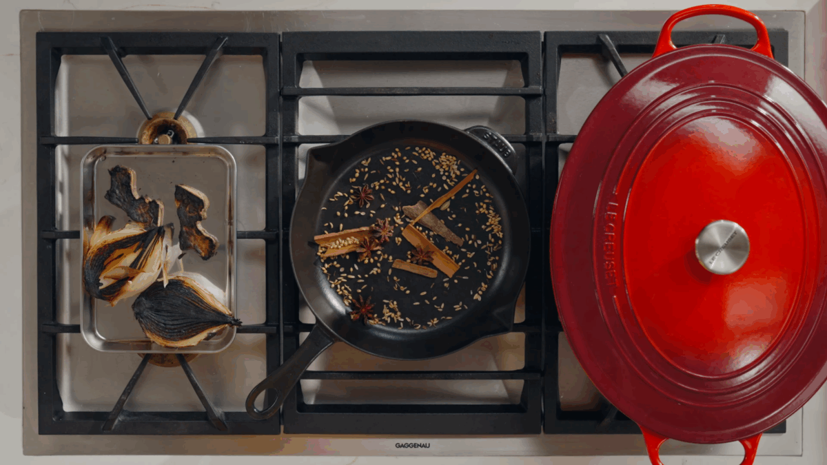 Beef pho broth spices toasting in a cast-iron skillet.