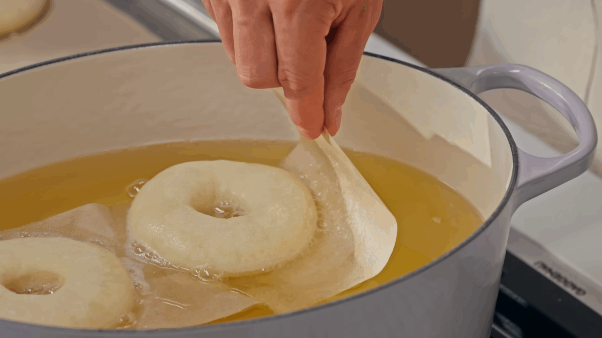 Nick DiGiovanni dropping yeast donuts into a pot of oil. 