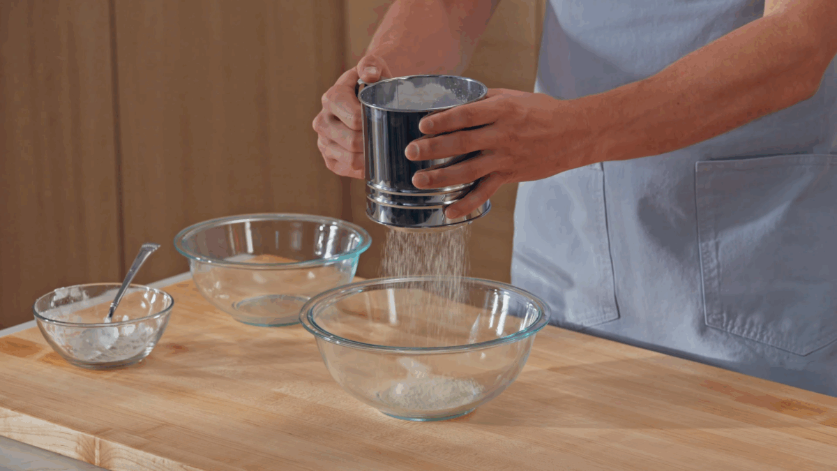 Nick DiGiovanni sifting dry ingredients for macaron batter into a bowl. 
