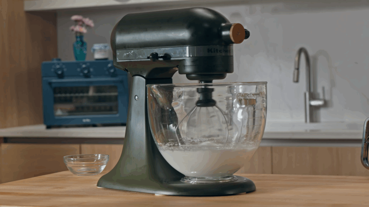 Egg whites being whipped in a stand mixer. 