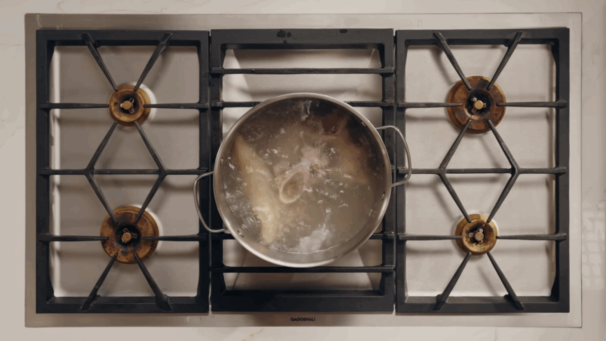 Nick DiGiovanni boiling pork skin and bones in a pot. 