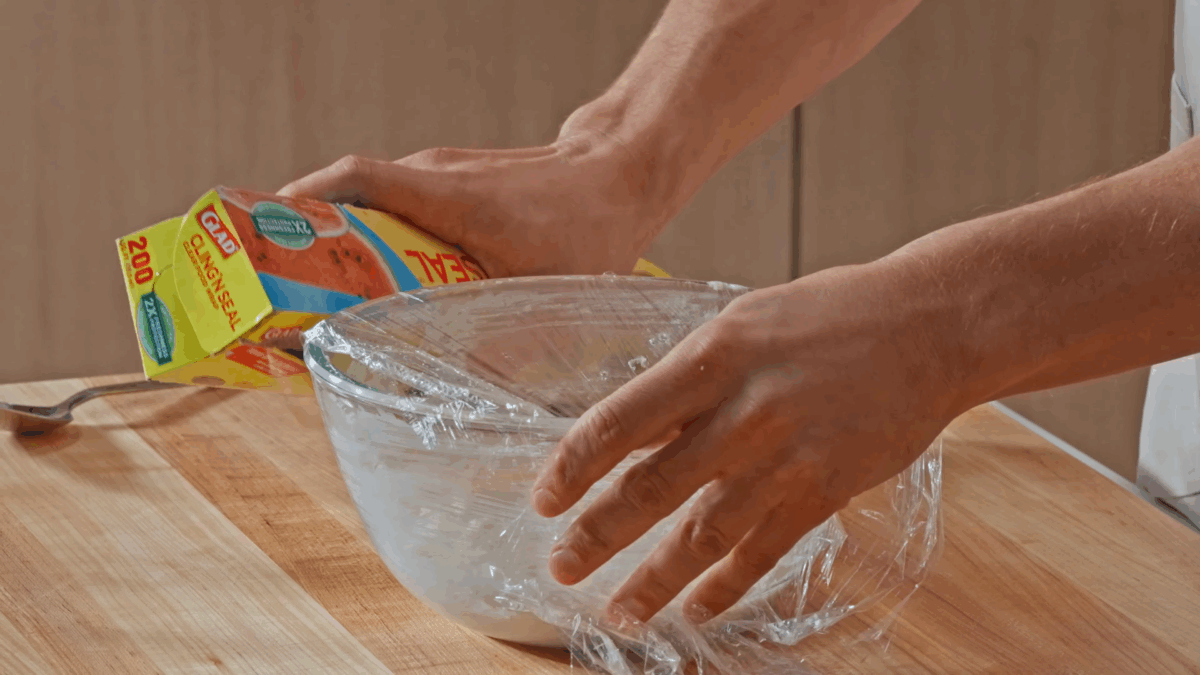 Nick DiGiovanni covering a bowl of fluffy horseradish with plastic wrap.